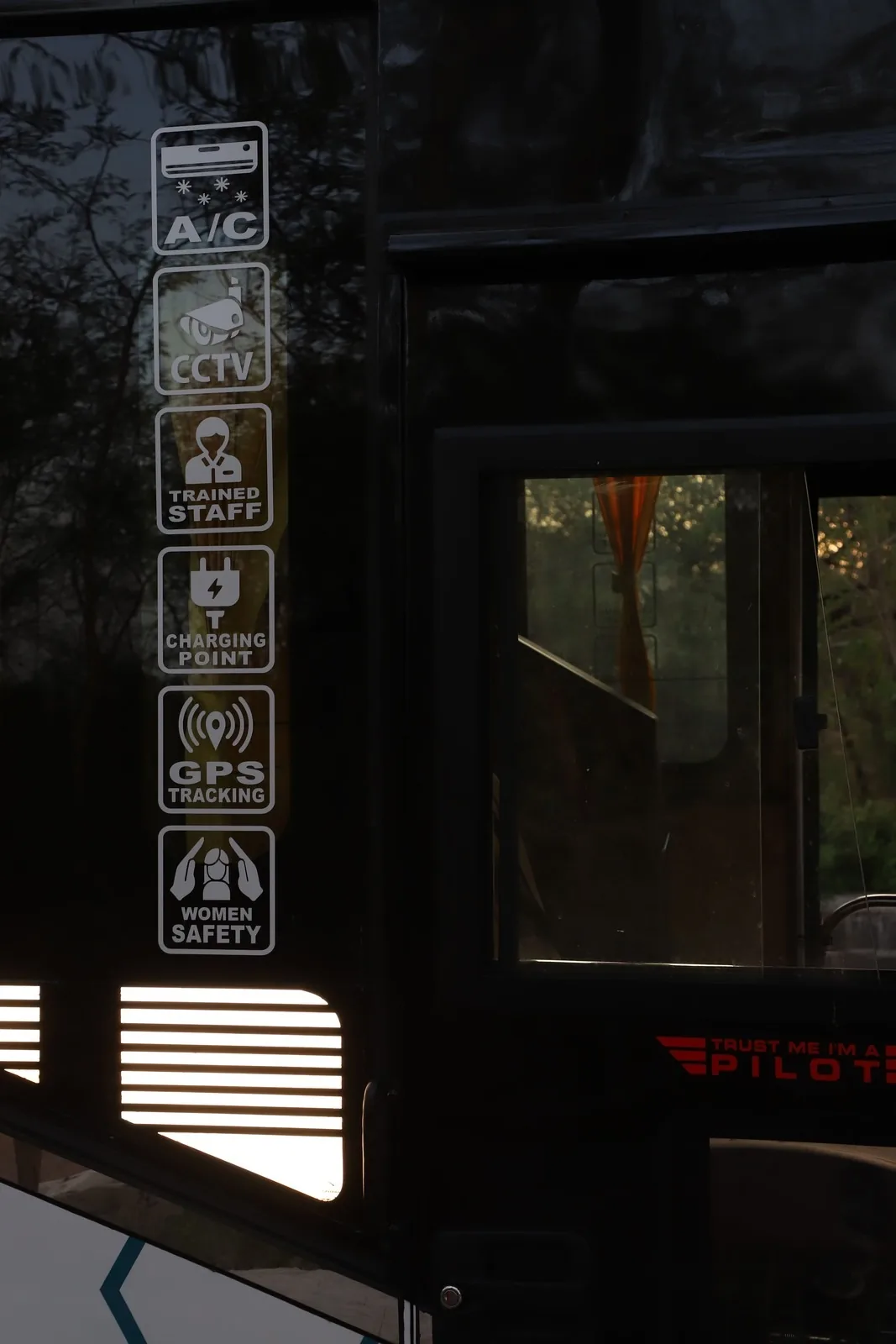 Bus window displaying CCTV, GPS tracking, WiFi and safety features